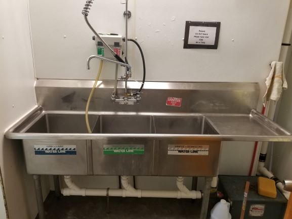 Three-bay commercial wash sink documented at the Brookhaven property